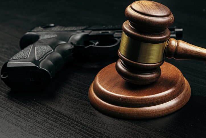 gun and judge's gavel on the table