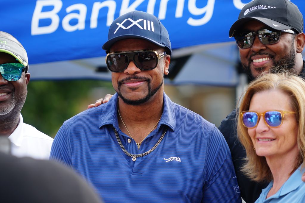 Three men wearing sunglasses and baseball caps, one with a "Banking" logo backdrop.