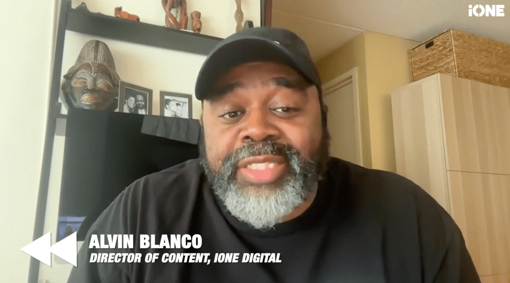A middle-aged Black man with a beard wearing a black cap and shirt, looking directly at the camera.