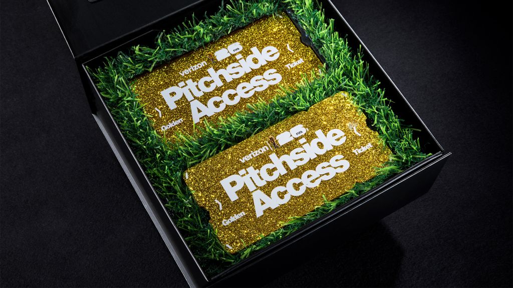 Two gold glitter-covered plaques on a bed of green grass, each displaying the text "Pitchside Access".