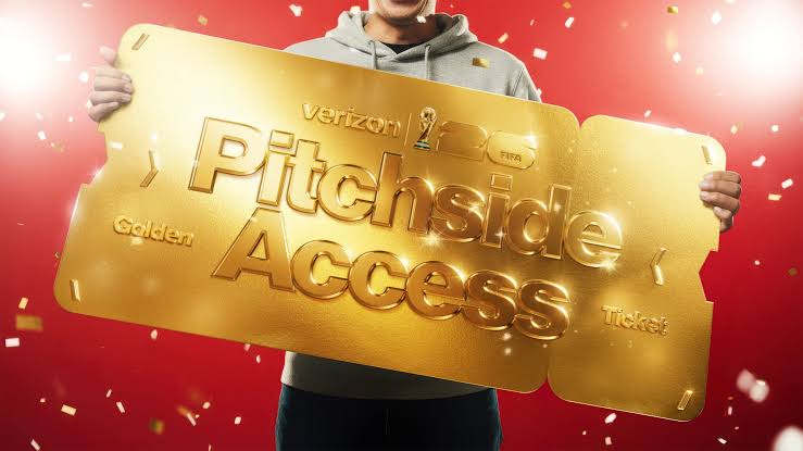 A person holding a large golden "Pitchside Access" ticket from Verizon, with confetti falling around them.