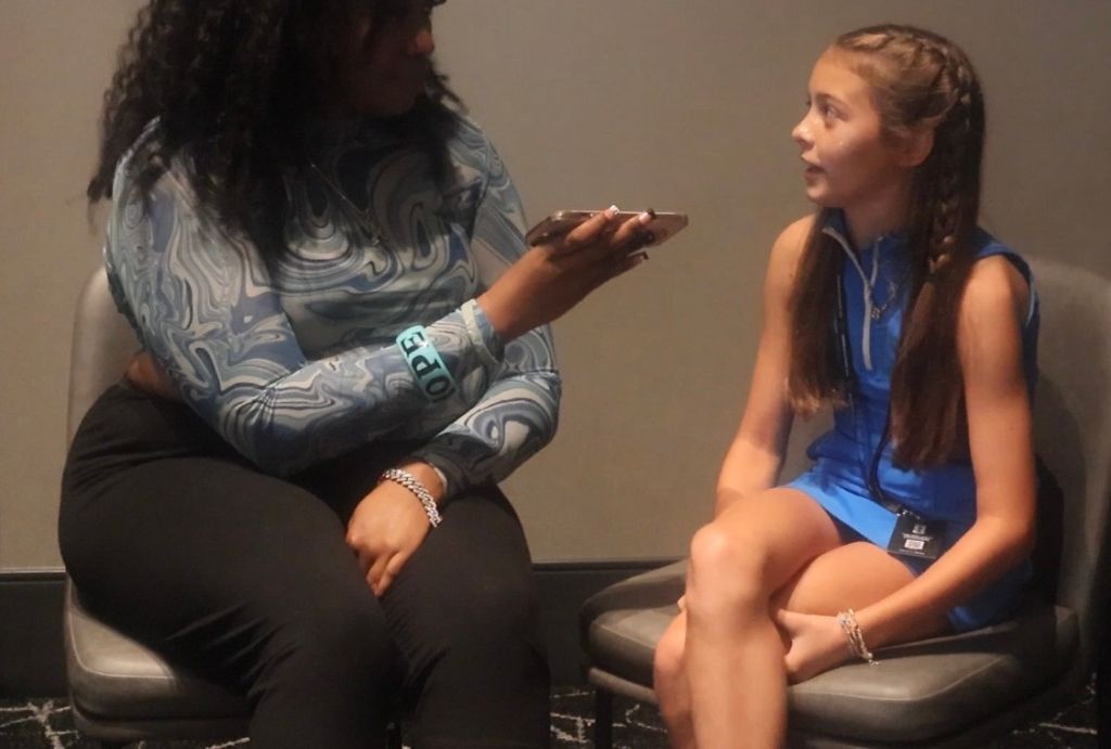 Two people, one adult and one child, sitting and interacting with a mobile device.