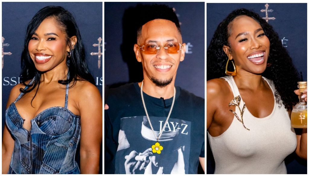 Three smiling people in formal attire: a woman in a blue dress, a man wearing a Jay-Z t-shirt, and a woman in a white tank top.