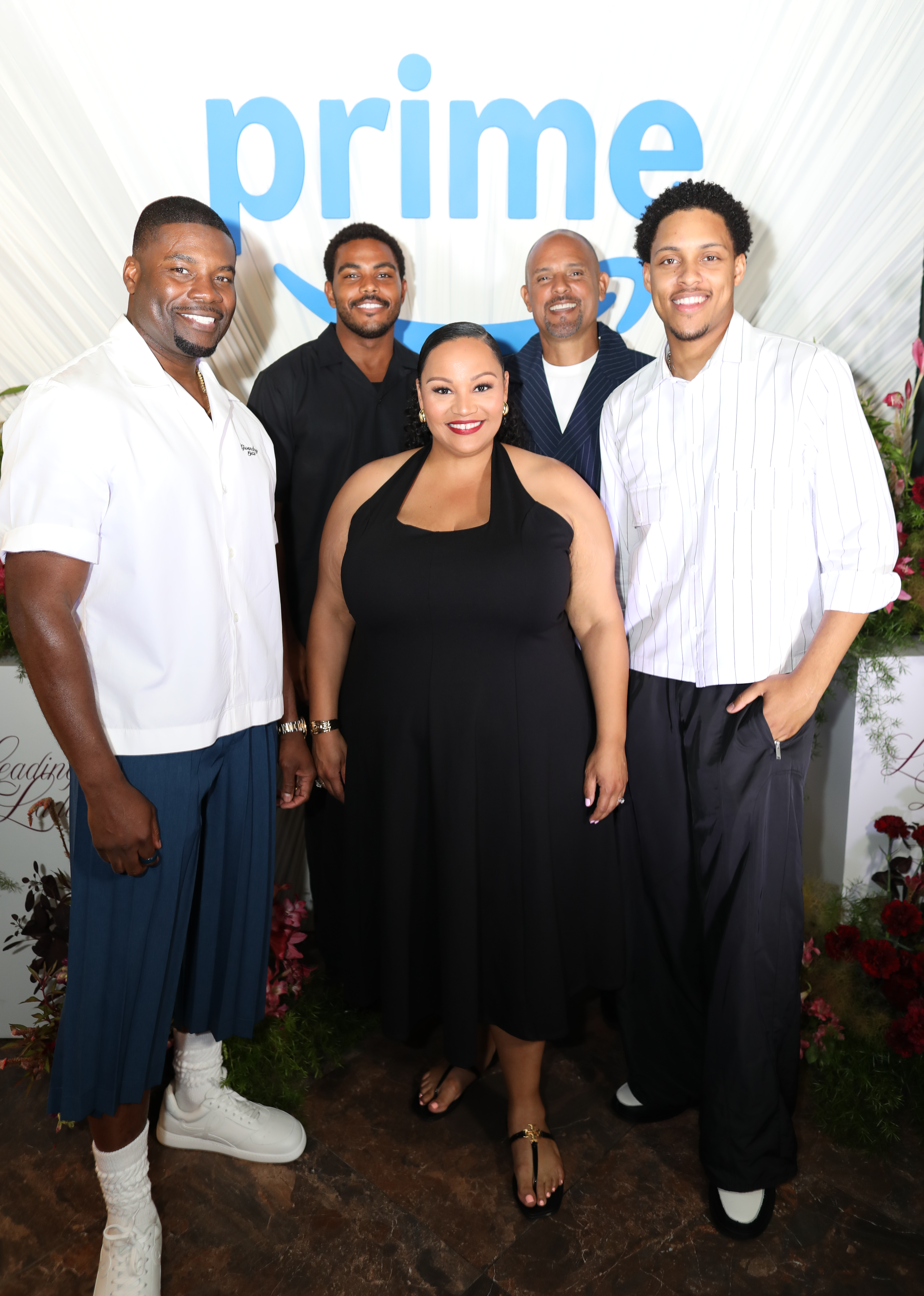 A group of five people, including four men and one woman, posing together in front of a backdrop with the "Prime" logo.