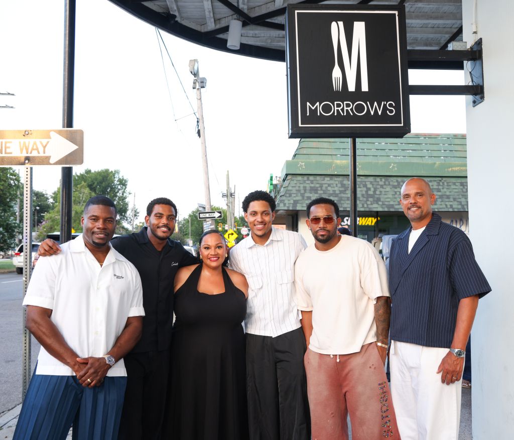 A group of 6 people standing in front of a sign for "Morrow's" restaurant or business.