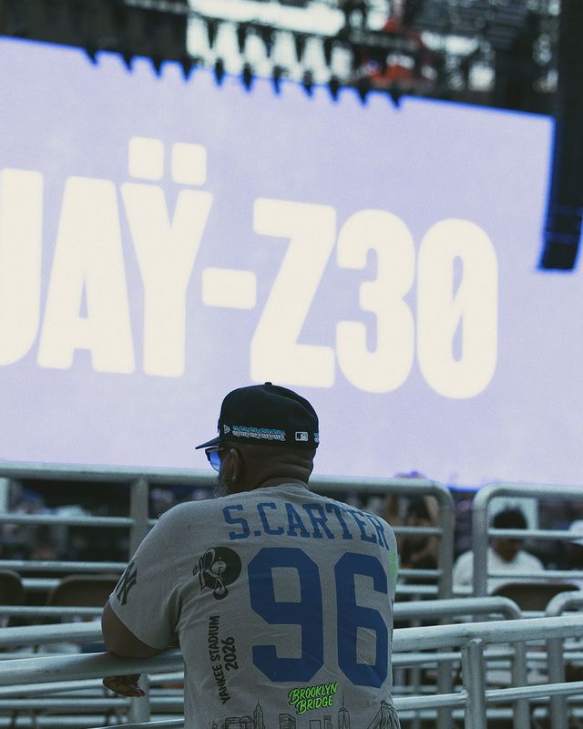 A person wearing a baseball jersey with the number 96 and the name "S.CARTER" stands in front of a large sign displaying "UAI-730".