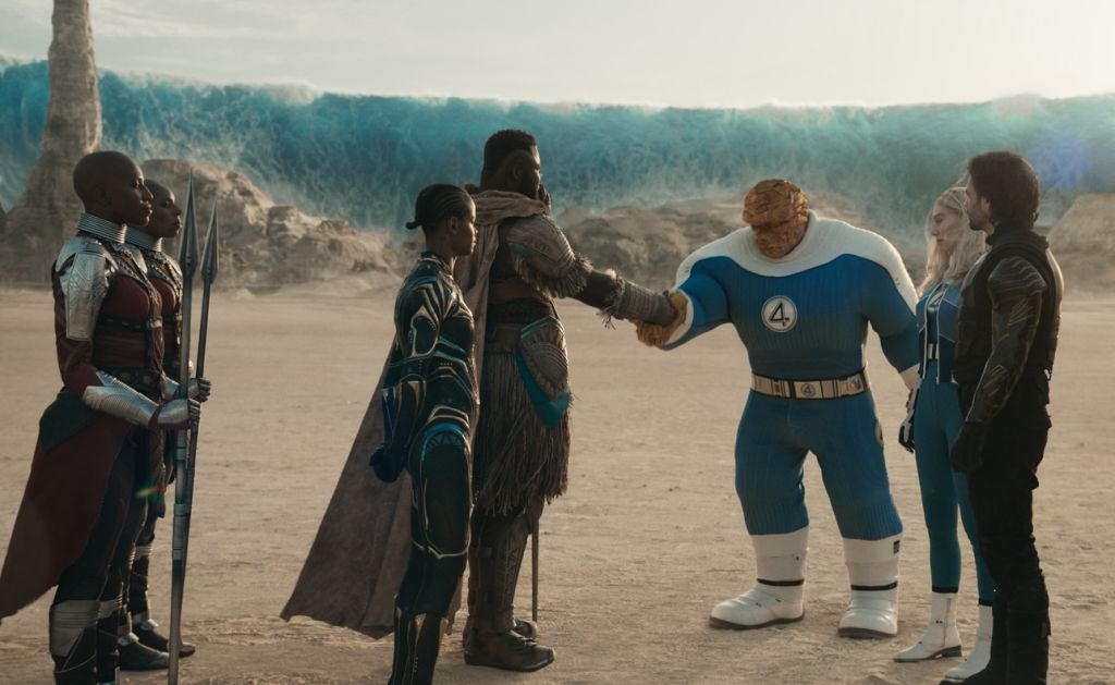 A group of superheroes, including the Dora Milaje, Shuri, M'Baku, The Thing, Invisible Woman, Winter Soldier, Falcon, and Ghost, standing in a desert landscape.