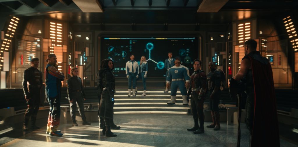 A group of superheroes, including Captain America, Ant-Man, and Thor, stand in a futuristic, high-tech setting with a large holographic display in the background.