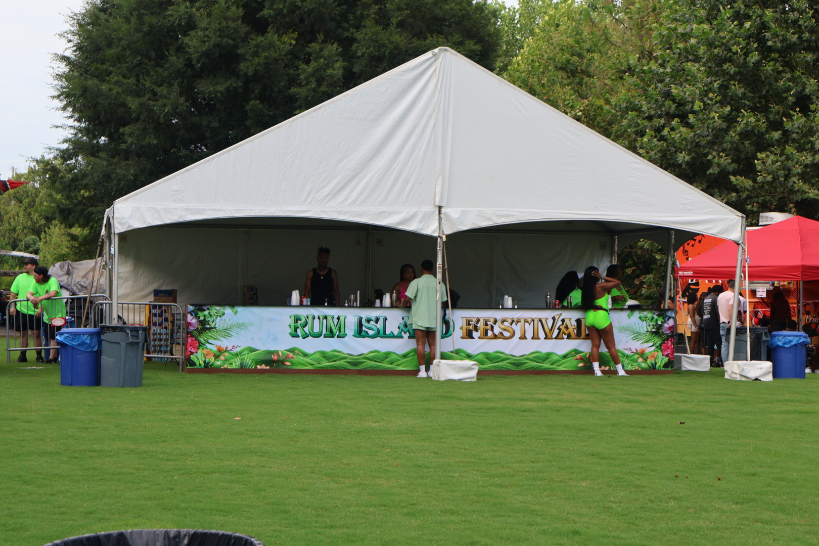 A large white tent with the text "Rum Island Festival" set up on a grassy field, with people visible inside and around the tent.