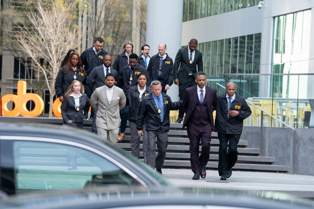 A group of FBI agents in suits and jackets standing on the steps of a building.