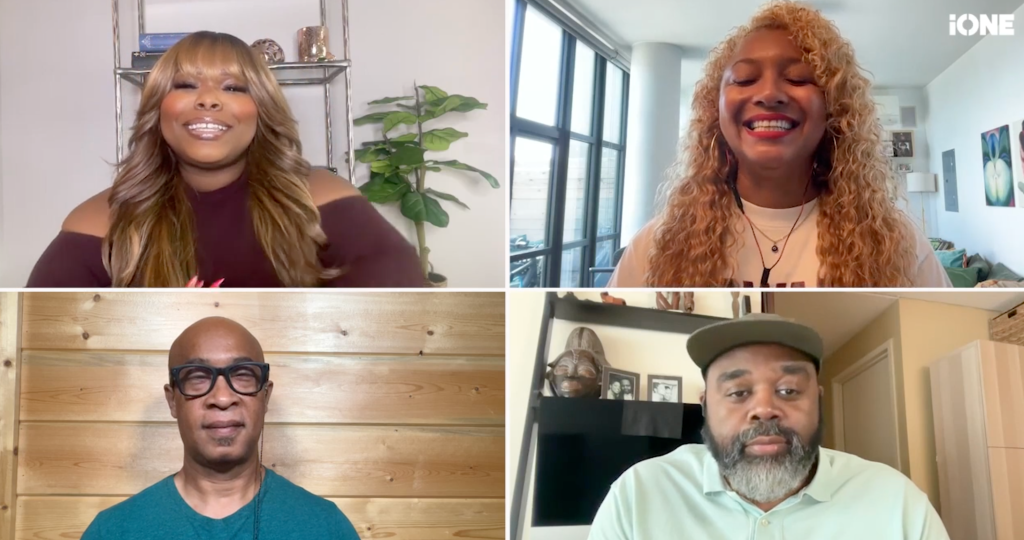Four people in a video call, smiling and conversing. The two women have curly hair and the two men have glasses and facial hair.