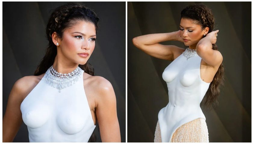 A woman in a white dress with a sparkling necklace, posing with her arms raised.