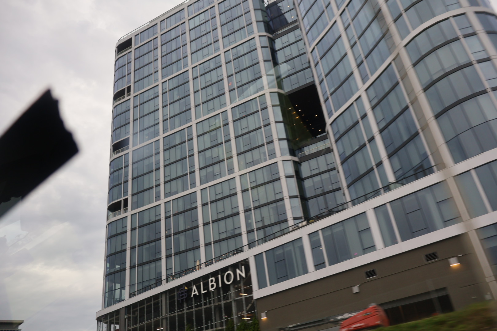 Tall glass and steel office building with the Albion logo prominently displayed.