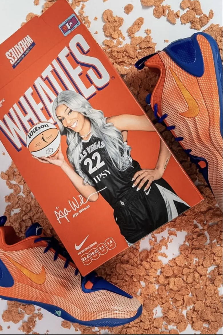 A basketball player wearing a Las Vegas Aces jersey and holding a Wilson basketball, surrounded by Shredded Wheat cereal.
