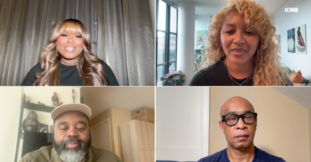 Four people in a video call, including a woman with curly blonde hair, a woman with curly brown hair, a man with a beard, and a man wearing glasses.