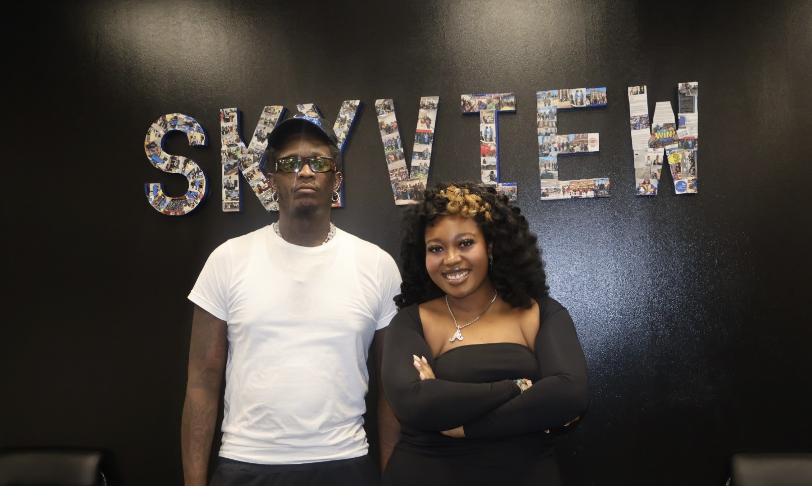 Two people standing in front of a wall with the text "SKYVIEW" displayed prominently.